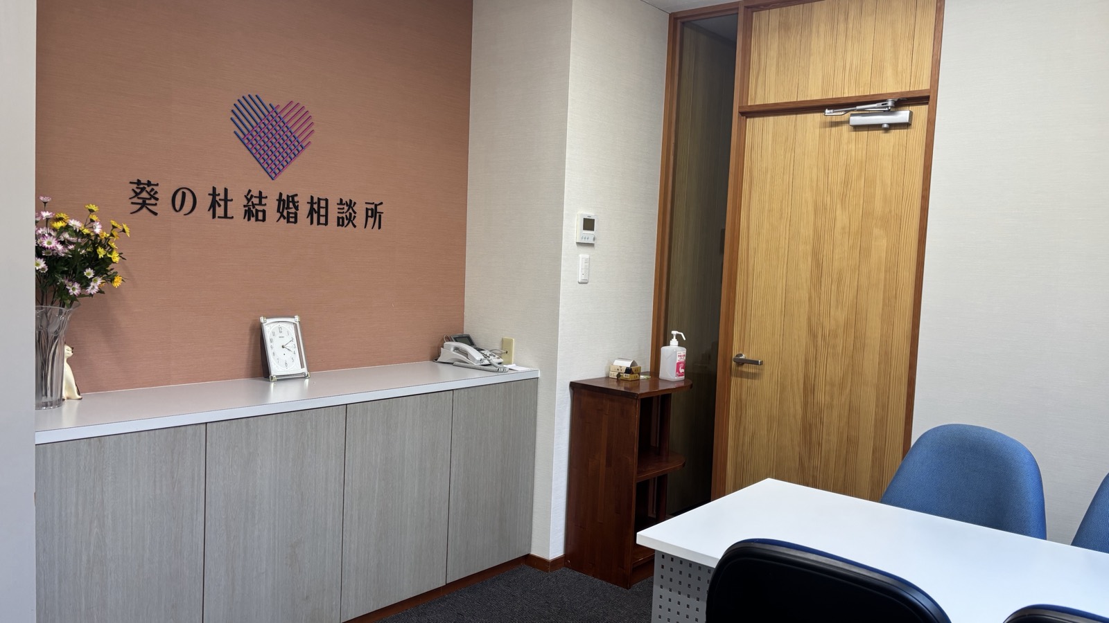 葵の杜結婚相談所の受付。壁に相談所のロゴと名称が掲げられている